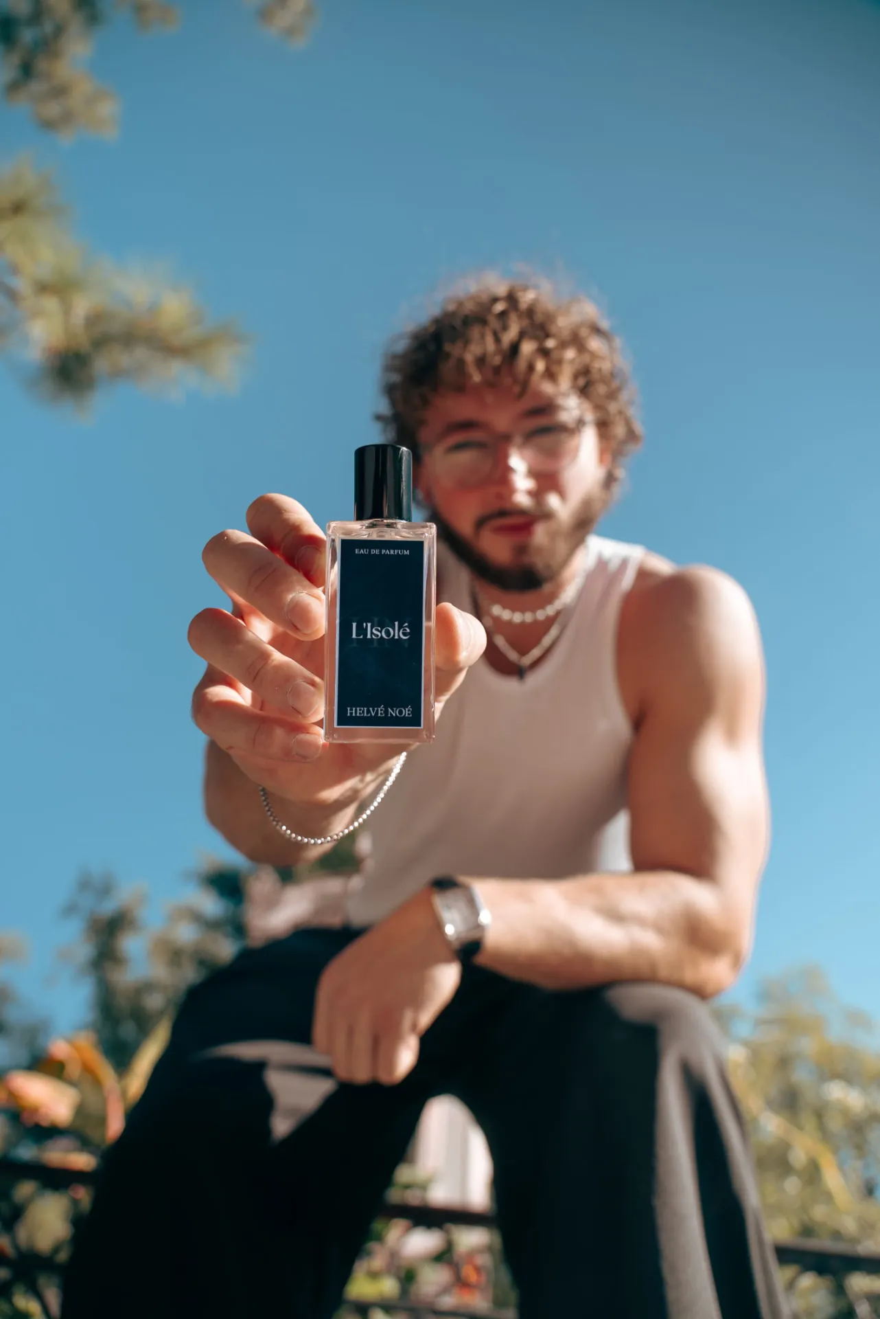 Flakon L’Isolé von Helvé Noé in einer Hand im Sonnenlicht